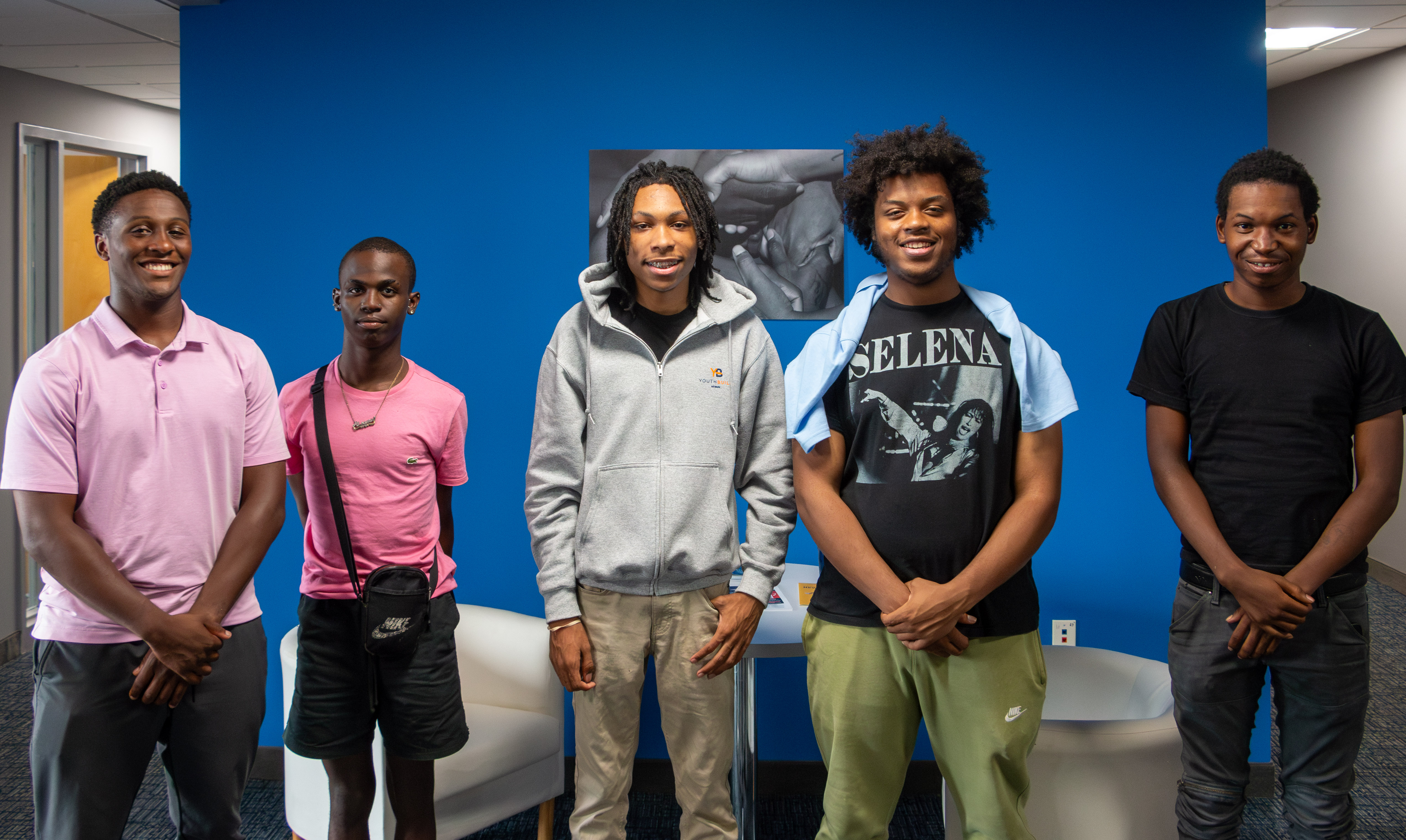 Five men pose in front of a blue background Five men pose in front of a blue background