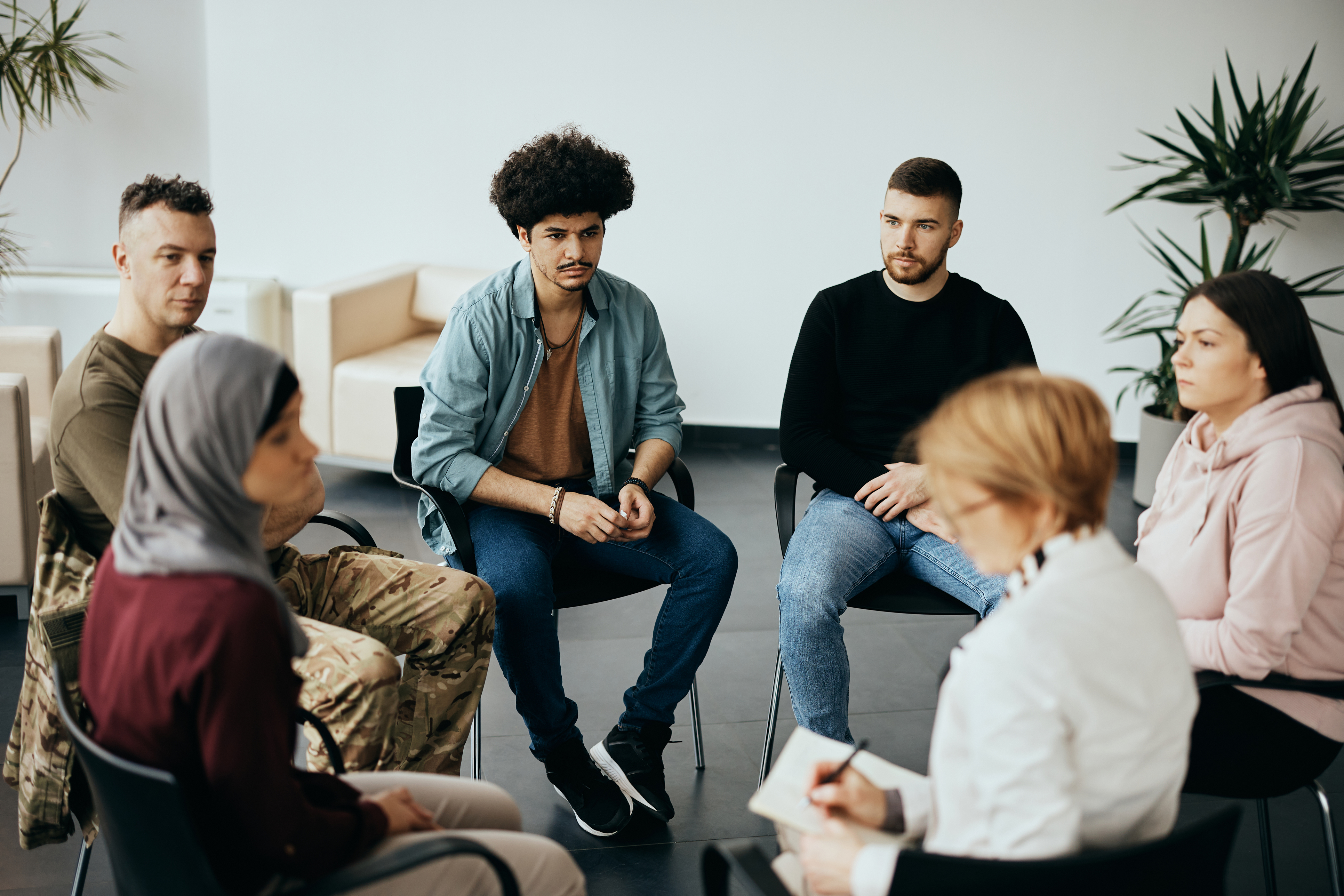 Stock image of six people seated in a circle at a group therapy session Stock image of six people seated in a circle at a group therapy session