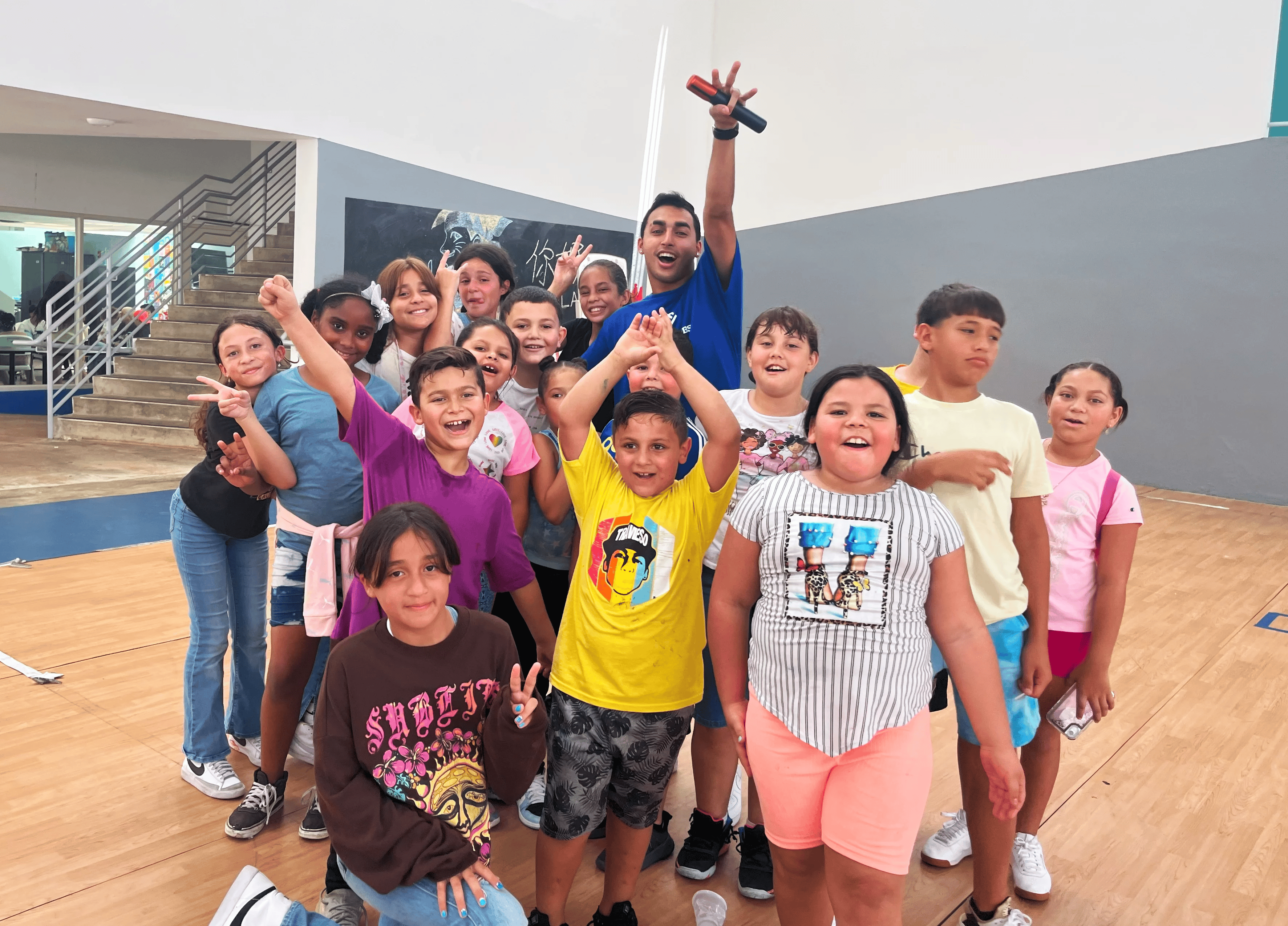 A group of youth pose for a photo in a gymnasium. A group of youth pose for a photo in a gymnasium.