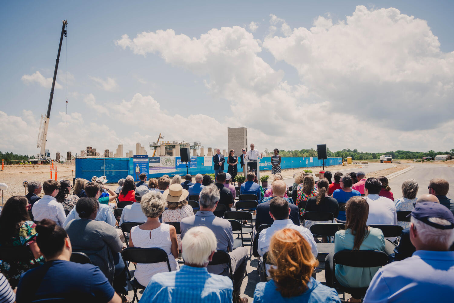 A group of people listening to a speaker on a stage